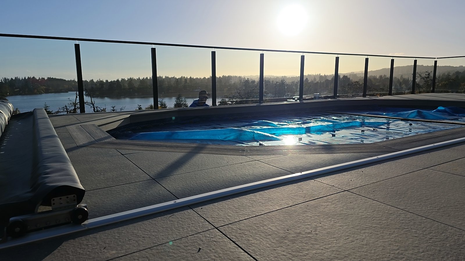 Glass railing overlooking the water in the setting sun