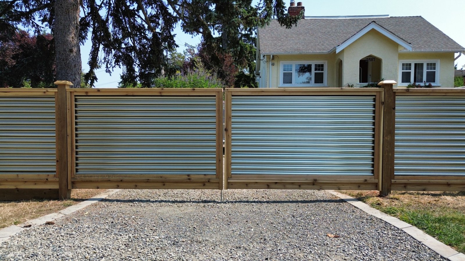 Custom double driveway gate with corrugated metal panels and timber frames