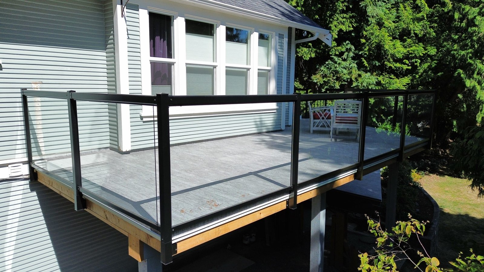 Black-framed glass railings on a finished deck